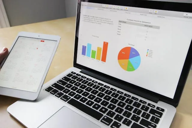 A laptop showing sales charts beside a tablet calendar